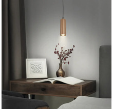 Zylindrische Pendelleuchte aus Holz über einem Schreibtisch mit Buch und Vase.