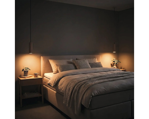 Modernes Schlafzimmer mit gepolstertem Bett, zwei Nachttischen aus Holz und tief hängenden Pendelleuchten mit warmem Licht.