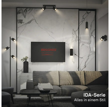 Modernes Wohnzimmer mit schwarzen Metall-Leuchten der Briloner Serie IDA vor einer hellen Marmorwand mit Sofa und Couchtisch.