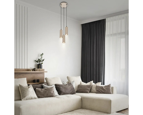 Modernes Wohnzimmer mit 3-flammiger Pendelleuchte, zylindrischen Schirmen und Ecksofa mit dekorativen Kissen.