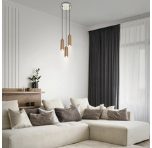 Dreiflammige Pendelleuchte mit zylindrischen Metallschirmen in einem hellen, modernen Wohnzimmer mit Ecksofa und dekorativen Kissen.