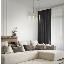 4-flammige Pendelleuchte mit zylindrischen Holzschirmen in einem hellen, modernen Wohnzimmer über einem großen Ecksofa mit Kissen.