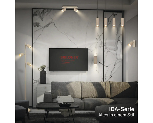 Modernes Wohnzimmer mit grauer Couch, Marmorwand und verschiedenen Leuchten der Briloner IDA-Serie wie Stehlampe, Deckenstrahler und Pendelleuchten.