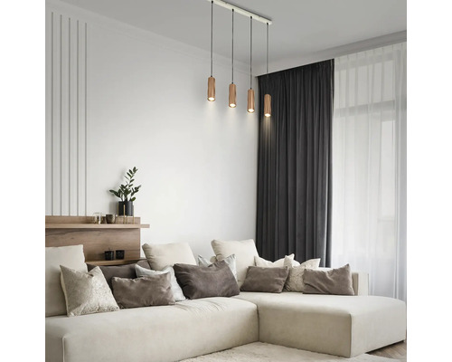 Vierflammige Pendelleuchte mit zylindrischen Holzschirmen in einem modernen Wohnzimmer über einem cremefarbenen Ecksofa.