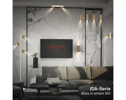 Modernes Wohnzimmer mit Metalllampen der Briloner IDA-Serie, grauem Sofa und Wand in Marmoroptik. Briloner Logo auf dem Fernseher.