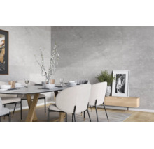 Modernes Esszimmer mit Wandfliesen in Steinoptik, einem Esstisch mit gepolsterten Stühlen und dekorativen Elementen in hellem Ambiente.
