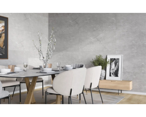 Modernes Esszimmer mit Wandfliesen in Steinoptik, einem Esstisch mit gepolsterten Stühlen und dekorativen Elementen in hellem Ambiente.