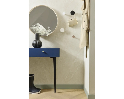 Modern gestalteter Flur mit blauem Konsolentisch, rundem Spiegel, schwarzen Gummistiefeln und Wandhaken an einer hellen, strukturierten Wand.