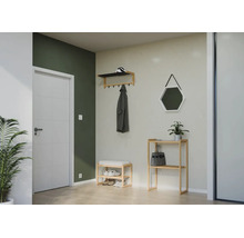 Organisierte Diele mit Garderobe, Schuhbank und Regal aus Holz sowie sechseckigem Spiegel und weißer Tür vor grüner und grauer Wand.
