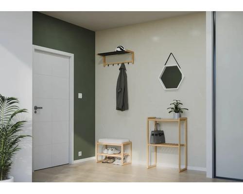 Organisierte Diele mit Garderobe, Schuhbank und Regal aus Holz sowie sechseckigem Spiegel und weißer Tür vor grüner und grauer Wand.