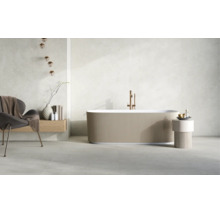 Freistehende Badewanne mit gerippter Außenwand, Standarmatur in Kupferoptik, Sessel und Dekoration in einem hellen, modernen Badezimmer.