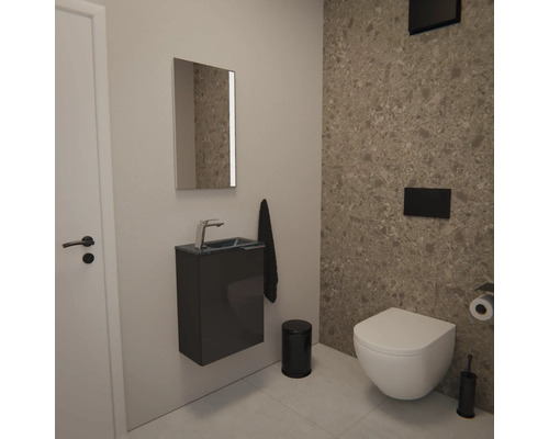 Modernes Gäste-WC mit wandhängendem WC, dunklem Waschtischunterschrank, Spiegel und Wandfliesen in Natursteinoptik im minimalistischen Stil.