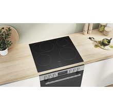 Bosch Induktionskochfeld mit vier Kochzonen und Bosch Einbaubackofen integriert in eine helle Küchenarbeitsplatte in Holzoptik.