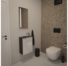 Modernes Gäste-WC mit wandhängendem Waschtisch, Spiegel mit Beleuchtung, Wand-WC und schwarzen Badaccessoires vor einer Wand in Terrazzo-Optik.