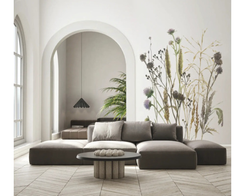 Modernes Wohnzimmer mit modularem Sofa und großer Fototapete mit botanischem Wildblumen-Motiv. Heller Raum mit Parkettboden aus Holz.