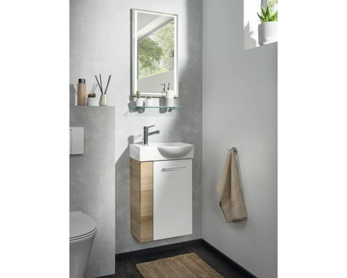 Gäste-WC-Set bestehend aus Waschbeckenunterschrank in Holzoptik und Weiß, weißem Keramikwaschbecken, LED-Spiegel und Glasablage in hellem Badezimmer.