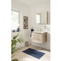 Helles Badezimmer mit wandhängendem Waschtischunterschrank in Holzoptik, weißem Waschbecken, Spiegelschrank, blauer Badematte und Dekoration.