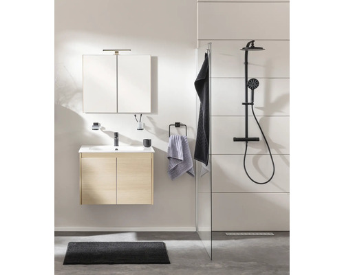 Modernes Badezimmer mit hellem Waschtischunterschrank in Holzoptik, Spiegelschrank, schwarzer Armatur und Duschsystem hinter einer Glaswand.