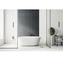 Modernes, helles Badezimmer mit freistehender Badewanne vor einer dunklen Fliesenwand, minimalistischem Regal und Holzhocker.