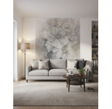 Modernes, helles Wohnzimmer mit grauem Sofa, dunklem Couchtisch und einer großflächigen Blumentapete an der Wand hinter dem Sofa.