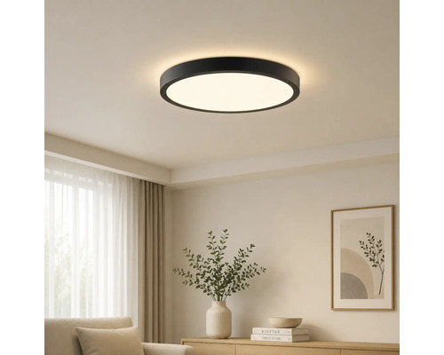 Moderne runde LED-Deckenleuchte mit schwarzem Rahmen in einem hellen Wohnzimmer.