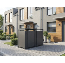 Mülltonnenbox aus Metall für drei Tonnen vor einem modernen Wohnhaus mit Holzfassade und gepflastertem Vorplatz.