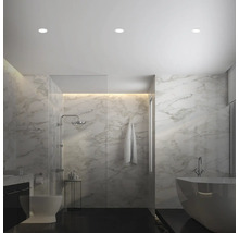 Modernes Badezimmer mit Marmorfliesen, begehbarer Dusche, freistehender Badewanne und Deckeneinbaustrahler für eine helle und elegante Atmosphäre.