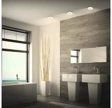 Modernes Badezimmer mit Doppelwaschtisch, Einbaustrahlern in der Decke, Badewanne und Wandverkleidung in Holzoptik.