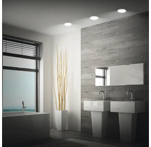 Modernes Badezimmer mit Doppelwaschbecken, Badewanne und drei runden LED Einbaustrahlern an der Decke.
