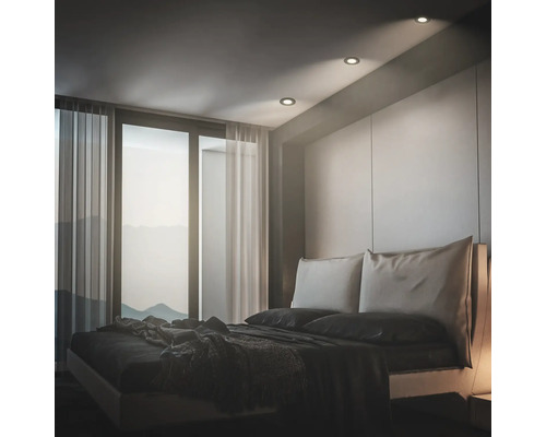 Modernes Schlafzimmer mit Einbaustrahler in der Decke, bodentiefem Fenster mit Vorhängen und einem bequemen Doppelbett.