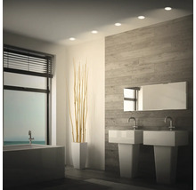 Modernes Badezimmer mit Doppelwaschbecken, Badewanne, Holzoptikwand und integrierten Deckenstrahlern.