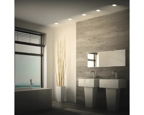 Modernes Badezimmer mit Doppelwaschbecken, Badewanne, Holzoptikwand und integrierten Deckenstrahlern.
