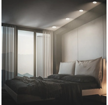 Modernes Schlafzimmer mit Einbaustrahlern in der Decke die ein warmes Licht auf das Bett werfen und eine stimmungsvolle Atmosphäre schaffen.