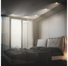 Modernes Schlafzimmer mit Einbaustrahlern in der Decke, die den Raum sanft beleuchten und eine behagliche Atmosphäre schaffen.