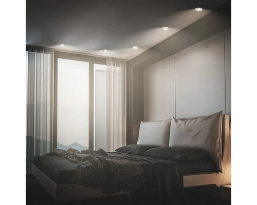 Modernes Schlafzimmer mit Einbaustrahlern in der Decke, die den Raum sanft beleuchten und eine behagliche Atmosphäre schaffen.