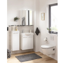 Modernes, helles Badezimmer-Set mit weißem Waschbeckenunterschrank, Spiegelschrank, Hochschrank und wandhängendem WC auf Holzoptik-Boden.