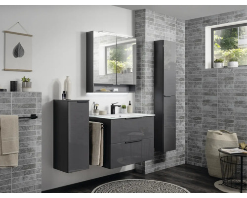 Modernes Badezimmermöbel-Set in Grau mit Waschtischunterschrank, Spiegelschrank und zwei Hochschränken vor einer Wand in Steinoptik.