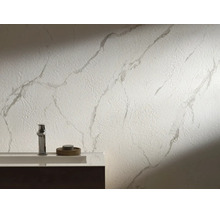 Modernes Badezimmer mit strukturierter Wand in Marmoroptik hinter einem Waschbecken und einer verchromten Armatur.