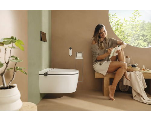 Wandhängendes Dusch-WC in einem modernen, hellen Badezimmer mit einer Frau auf einer Holzbank und minimalistischer Einrichtung.