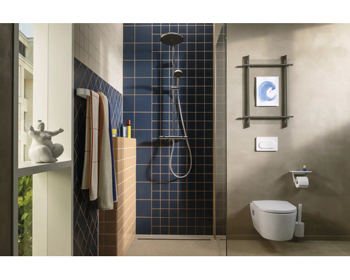 Modernes Badezimmer mit blauen Quadratfliesen in der Dusche, Wandtoilette, Duschsystem und Handtuchhalter.