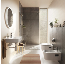 Modernes Badezimmer mit wandhängendem Waschbecken, ovalem Spiegel, begehbarer Dusche mit grauen Fliesen, Wand-Toilette und Bidet. Hell strukturiert.