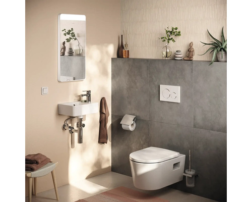 Modernes Gäste-WC mit wandhängender Toilette, kompaktem Handwaschbecken, beleuchtetem Spiegel und Drückerplatte.