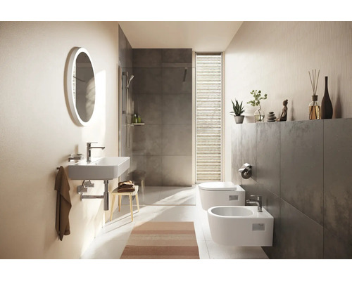 Modernes Badezimmer mit wandhängendem Waschbecken, ovalem Lichtspiegel, begehbarer Dusche mit grauen Fliesen, wandhängendem WC und Bidet.