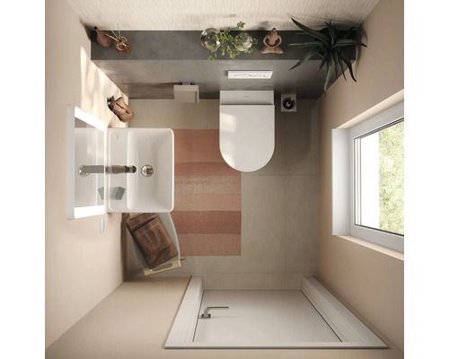 Draufsicht auf ein modernes, helles Badezimmer mit weißem Waschbecken, Wandtoilette, gestreiftem Teppich und Tageslicht durch ein Fenster.