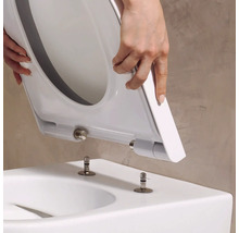 WC-Sitz mit Take-Off-Funktion wird auf die Befestigungsbolzen einer Toilette aufgesetzt.