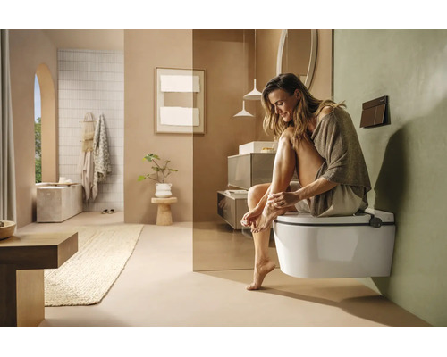 Modernes, helles Badezimmer mit wandhängendem WC, minimalistischen Möbeln und Dekoration in natürlichen Erdtönen.