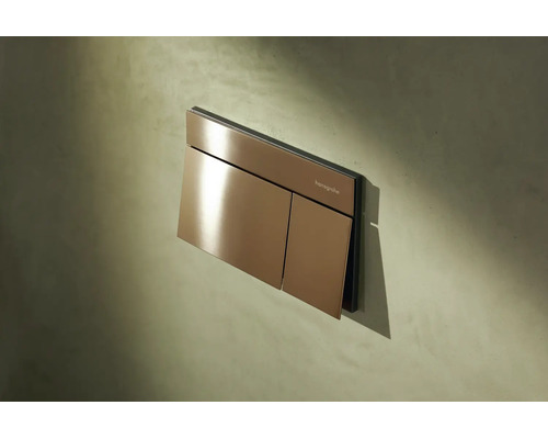 Hansgrohe Betätigungsplatte für WC mit 2-Mengen-Spülung in Bronze-Optik an einer Wand montiert.