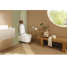 Modernes Badezimmer mit weißem Dusch-WC zur Wandmontage, Holzbank und rundem Fenster. Minimalistisches Design in Erdtönen.