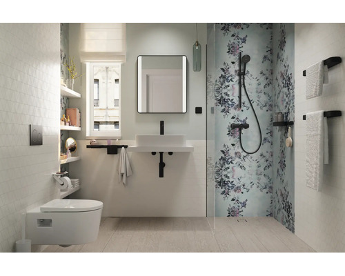 Modernes, helles Badezimmer mit wandhängendem WC, weißem Waschtisch, schwarzer Armatur und Dusche mit floralem Muster.
