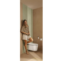 Modernes Badezimmer mit wandhängendem Dusch-WC, Fernbedienung, integriertem Toilettenpapierhalter und einer Frau.